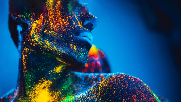 Key_Visual_CWS_2024_768x432 Frauen-Silhouette mit Neon-Pulver vor blauem Hintergrund